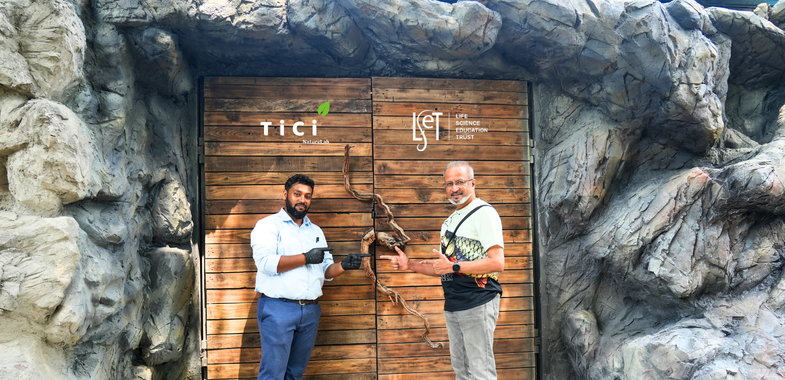 Founder and Director of TiCi NatureLab standing with the Founder and Editor of The Weekend Aquarist in front of the aquarium gallery entrance featuring man-made rock structures and immersive ecosystem design.